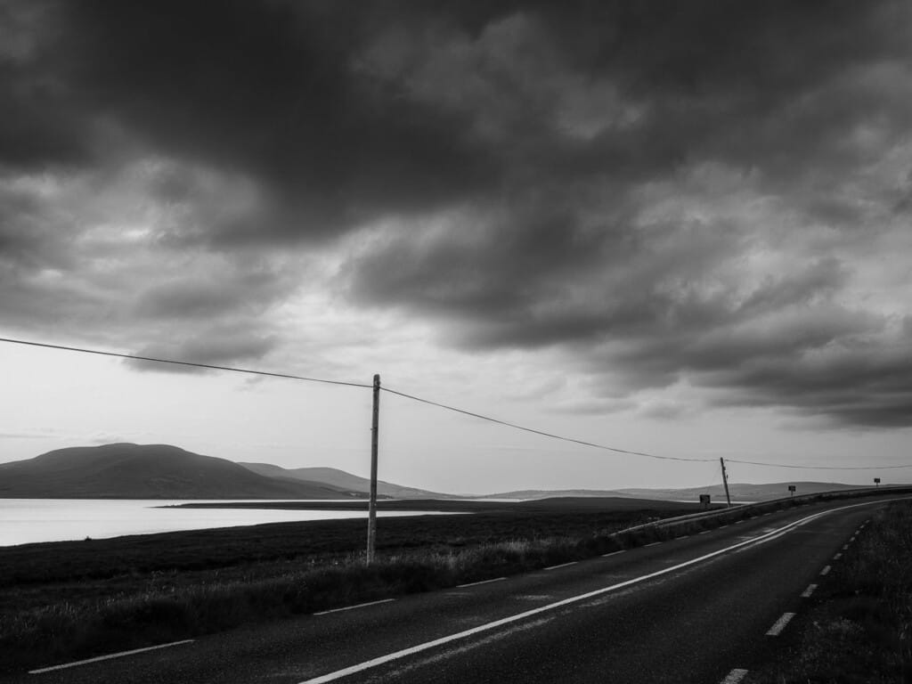 Empty Asphalt Country Road Leading To Dramatic Cloudy Sky